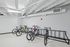 Modern indoor bike storage with sleek design and multiple racks in a well-lit apartment facility.