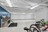Bright and spacious indoor bike storage area with secure racks and modern pet wash station, perfect for urban living.