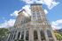 Majestic high-rise building under a brilliant blue sky, showcasing elegant architecture with arched windows and sunlit facade.