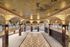 Luxurious grand hallway adorned with intricate gold detailing, ornate murals, and stunning marble columns, exuding timeless elegance and sophistication.
