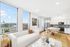 Bright and modern apartment featuring a cozy living area, sleek kitchen, and large windows with stunning city views.