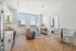 Modern apartment interior with sleek kitchen, cozy living area with stunning city view, and elegant bar seating.