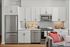 Modern kitchen with sleek stainless steel appliances, white cabinetry, and stylish backsplash, creating a cozy and inviting atmosphere.