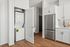 Modern kitchen with sleek stainless steel appliances and in-unit laundry, offering convenience and style.