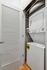 Modern stacked washer and dryer in a chic laundry nook with sleek white doors and elegant wooden flooring.