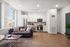 Sleek modern apartment living area with open kitchen, featuring stainless steel appliances, cozy seating, and expansive windows for natural light.