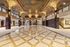 Grand lobby featuring exquisite marble floors, ornate gold-accented columns, and a stunning intricately painted ceiling.