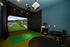 Modern entertainment room featuring a state-of-the-art golf simulator, surrounded by elegant seating and ambient lighting.