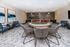 Luxurious entertainment room with a chic circular gaming table, plush seating, and modern art accents.