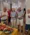Vibrant community gathering in a stylish apartment setting, showcasing a well-lit room with modern decor and a table filled with a variety of snacks and drinks.