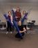 Spacious and inviting community room with four joyful individuals holding yoga mats, highlighting a vibrant and friendly living environment.