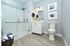 Bright modern bathroom with elegant walk-in shower, stylish vanity, and calming blue accents.