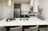 Modern kitchen with sleek countertops, stainless steel appliances, and elegant lighting, perfect for stylish living.