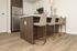 Modern kitchen area with sleek stainless steel appliances, stylish island with elegant bar stools, and inviting wood flooring.