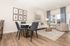 Bright and modern living room with elegant decor, featuring stylish furniture, cozy dining area, and large windows with sheer curtains for plenty of natural light.