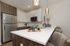 Modern kitchen with elegant white and wood cabinetry, sleek stainless steel appliances, and chic pendant lighting.