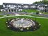 Elegant apartment complex with modern design, featuring beautifully landscaped gardens and a serene fountain for a tranquil living environment.