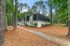 Charming two-story apartment building nestled in a lush forest setting, featuring crisp white brick exterior and modern design.