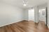 Bright and inviting bedroom with elegant wood flooring and a spacious walk-in closet, perfect for modern living.
