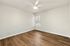 Bright and airy room with elegant hardwood floors, a modern ceiling fan, and a large window providing natural light.