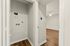 Modern apartment with pristine white walls, sleek wood flooring, and a utility nook, seamlessly blending style and functionality.