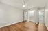 Sleek and modern bedroom with warm wooden flooring, ample closet space, and bright lighting, perfect for comfortable living.