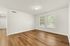 Bright and inviting room with large windows, sleek hardwood floors, and modern ceiling light in a spacious apartment.