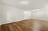 Spacious living area with elegant wood flooring and modern lighting.