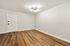 Bright and inviting room with elegant wood flooring and a modern light fixture, perfect for personalizing your living space.