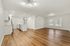 Bright open-concept living area featuring modern lighting, sleek hardwood floors, and a stylish kitchen with an island and stainless steel appliances.