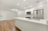 Modern open-concept kitchen with sleek stainless steel appliances, elegant white cabinetry, and a spacious island countertop, perfect for entertaining.