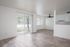 updated kitchen, dining and living space with vinyl plank flooring, new black fixtures, and sliding glass door