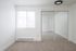 updated bedroom with new carpeting, black light fixture, mirrored closet doors, and window with blinds