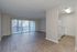 Spacious, light-filled living and kitchen area with sliding glass doors leading out the private patio at The Maples apartments in Portland, OR