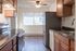 Bright and inviting kitchen featuring modern appliances, elegant cabinetry, and a large window for natural light.