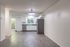 Charming open-concept apartment with modern kitchen, stainless steel appliances, and sleek laminate flooring.