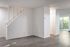 Bright and inviting living space featuring modern wood flooring, a stylish staircase, and access to a lush outdoor patio.