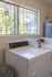 Bright and airy laundry room featuring commercial-grade Speed Queen dryer with large window offering scenic views.