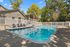 Inviting outdoor pool area with comfortable seating and lush green surroundings offering relaxing retreat.