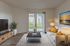 Bright and inviting living room with modern decor, large window with serene outdoor view, and cozy seating area.