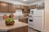 Contemporary kitchen design with modern appliances, warm wooden cabinetry, and sleek countertops.