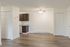 Bright and modern apartment featuring an open floor plan with elegant hardwood flooring, a stylish ceiling fan, and convenient kitchen access.