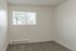Bright and airy room featuring plush carpet flooring and large window with a serene view, perfect for a cozy bedroom setup.