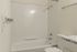 Modern bathroom featuring a sleek bathtub, granite countertop, and elegant chrome fixtures.