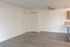 Bright and inviting apartment showcasing sleek hardwood floors, a ceiling fan, and modern kitchen countertops, perfect for stylish living.
