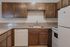Charming kitchen with elegant wooden cabinets, modern appliances, and a sleek countertop for a cozy cooking experience.