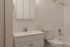 Bright and modern bathroom featuring a sleek vanity with storage, elegant fixtures, and a pristine bathtub-shower combo.