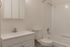 Modern and bright bathroom featuring a sleek white vanity, pristine bathtub, and elegant fixtures, ideal for relaxation.
