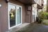 Charming apartment entrance with sliding glass doors and scenic garden view, perfect for enjoying natural light and tranquility.