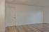 Inviting apartment entrance with elegant wood flooring and a minimalist design.